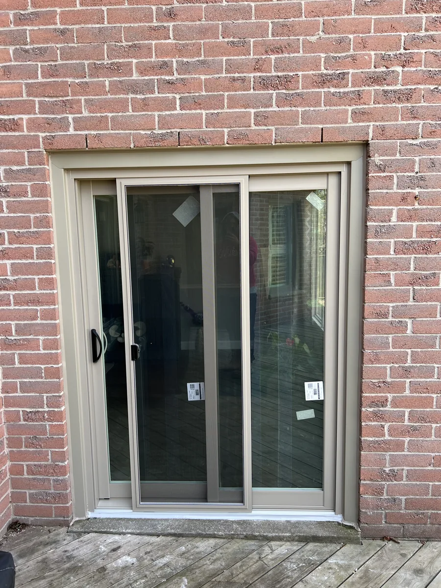 New almond sliding patio door installed in the red brick wall of the River Oaks home