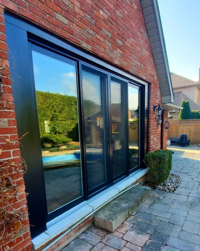 Black-framed patio doors installed on a red-brick GTA home