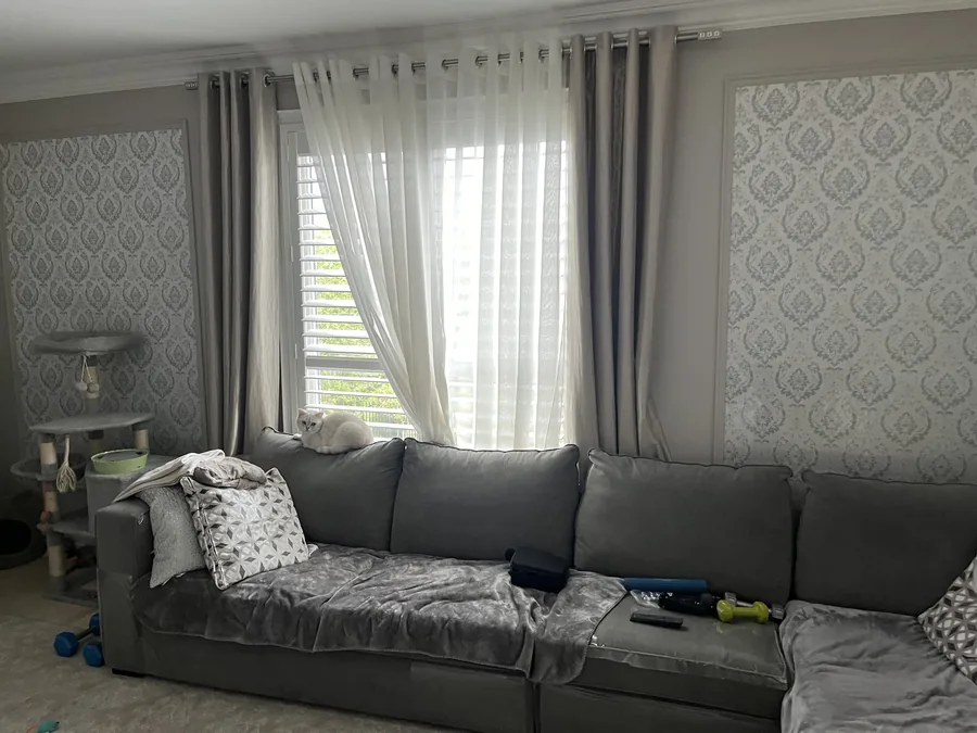 The living room before, with a small builder window and heavy curtains