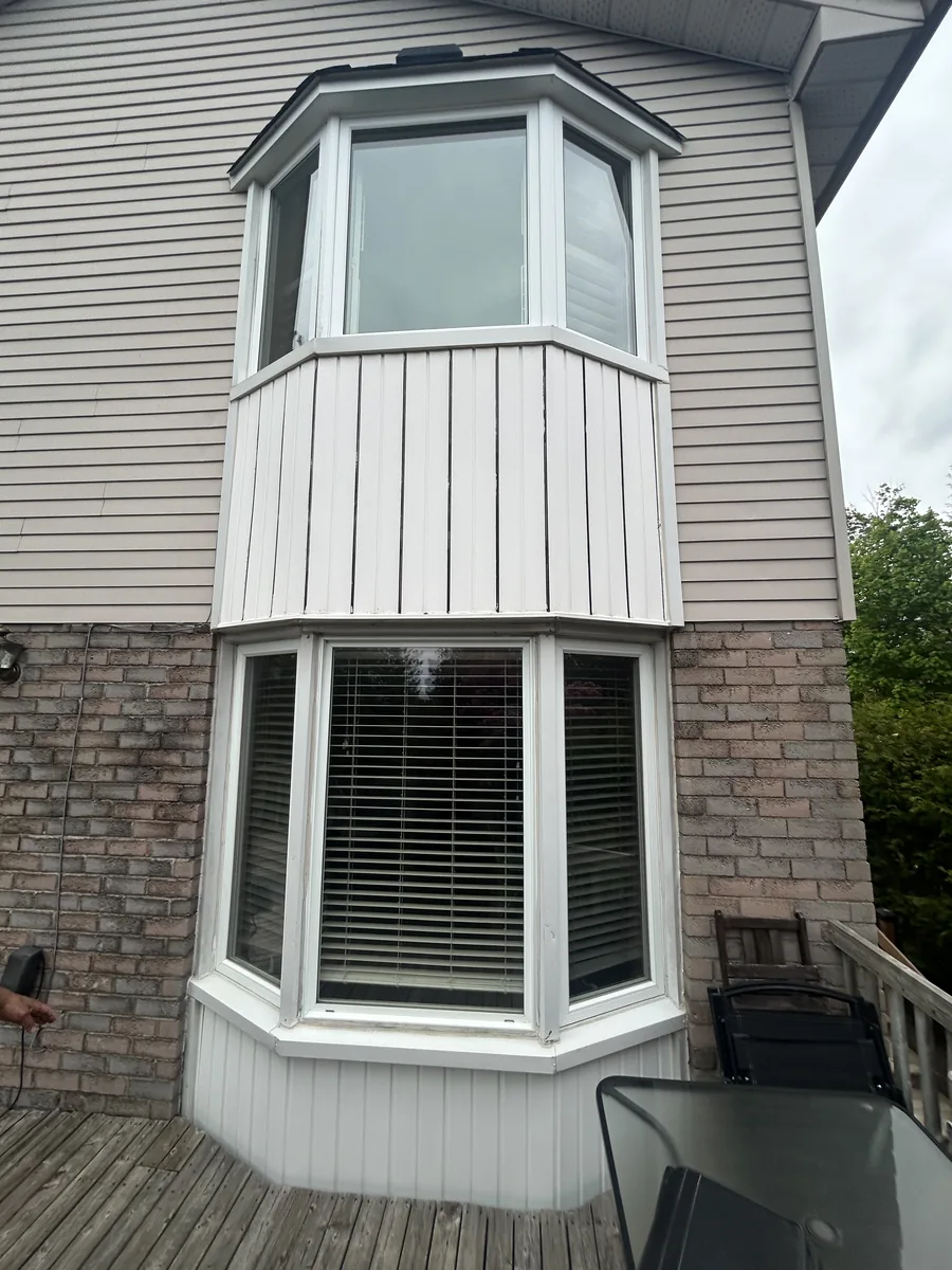 Before: two stacked projecting bay windows on the back of the Whitby home, one above the other
